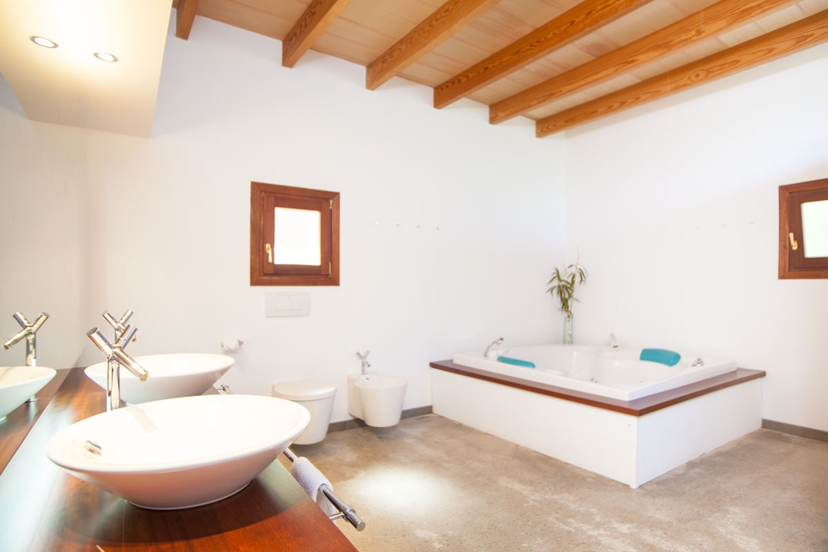 Finca de piedra natural con piscina y vistas a la bahía en un solar